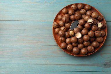 Macadamia fındıkları ve açık mavi ahşap masa üzerinde metal anahtar, üst manzara. Metin için boşluk