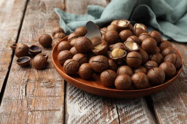 Macadamia fındıkları ve metal anahtar ahşap masada, yakın plan.