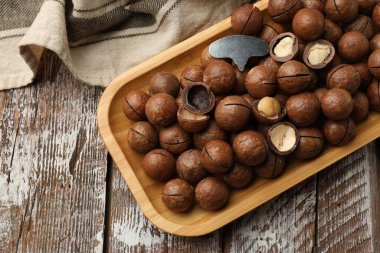 Macadamia fındıkları ve metal anahtar ahşap masada, üst manzara. Metin için boşluk