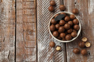 Macadamia fındığı ve metal anahtar tahta masada, düz yerde. Metin için boşluk