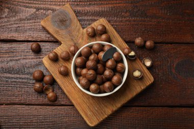 Macadamia fındıkları ve metal anahtar ahşap masada, üst manzara.