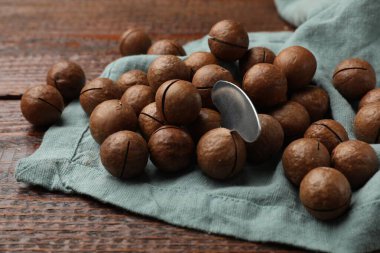 Macadamia fındıkları ve metal anahtar ahşap masada, yakın plan.