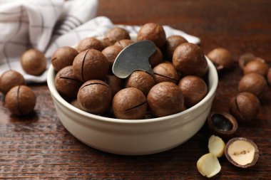 Macadamia fındıkları ve metal anahtar ahşap masada, yakın plan.