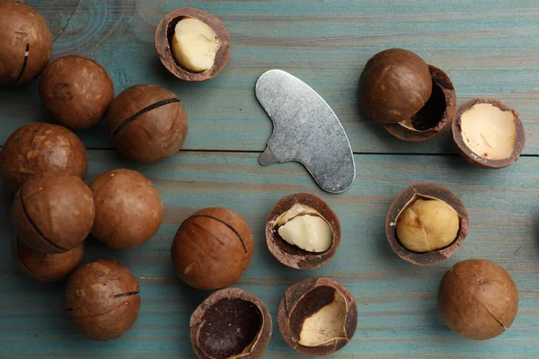 Macadamia fındığı ve metal anahtar açık mavi ahşap masa, düz yatıyordu.