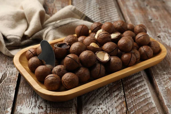 Macadamia fındıkları ve metal anahtar ahşap masada, yakın plan.