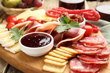 Tahta masa üzerinde farklı atıştırmalıklar ve şaraplar olan şarküteri tahtası, yakın plan.