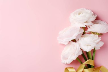 Pembe arka planda bir buket güzel ranunculus çiçeği, üst manzara. Metin için boşluk