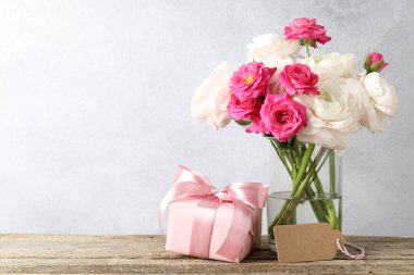 Boş kartlı güzel çiçekler ve ahşap masada hediye. Metin için boşluk