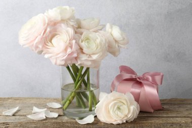 Güzel çiçekler ve hediye ahşap masada.