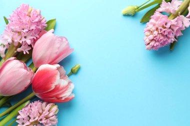 Açık mavi arka planda güzel çiçekler, düz uzanmış. Metin için boşluk