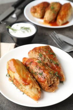 Gri masada servis edilen lezzetli lahana dürümleri, yakın plan.