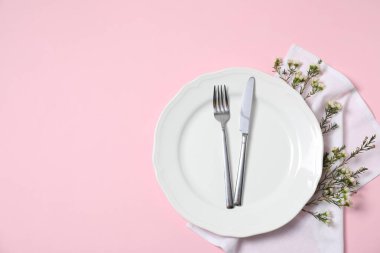 Pembe arka planda çiçek dekoru olan güzel bir masa. Metin için boşluk