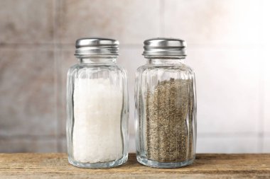 Ahşap masada tuzluk ve biberlikler, yakın plan.