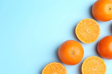 Açık mavi arka planda taze taze mandalinalar, düz uzanmış. Metin için boşluk