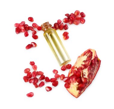 Bir şişe gerekli yağ ve taze nar, beyaz, üst görünümde izole edilmiş.