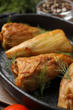 Tahta masada servis edilen lezzetli lahana dürümleri, yakın plan.