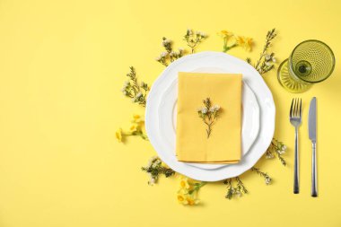 Sarı arka planda çiçek dekoru olan güzel bir masa. Metin için boşluk