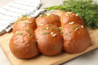 Sarımsaklı taze çörekler ve dereotlar ışık masasında, yakın plan.