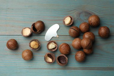 Macadamia fındığı ve metal anahtar açık mavi ahşap masa, düz yatıyordu.