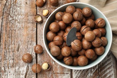 Macadamia fındığı ve metal anahtar tahta masada, düz yerde. Metin için boşluk