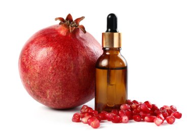 Yağ, tohum ve taze nar içeren şişe beyaza izole edilmiş.