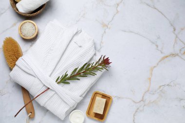 Bornoz ve spa ürünleri beyaz mermer masa üzerinde düz kompozisyon, metin için boşluk