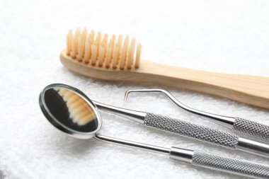 Beyaz havluda farklı diş aletleri, yakın plan.