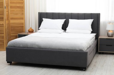 Yatak odasında temiz çarşafları olan rahat bir yatak.