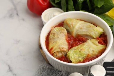 Lezzetli dolgulu lahana ruloları kasede ve hafif mermer masada malzemeler, yakın plan. Metin için boşluk