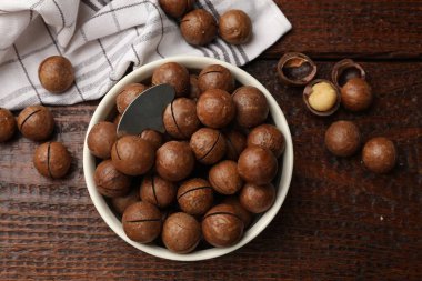 Macadamia fındıkları ve kasedeki metal anahtar tahta masada, düz yatıyordu.