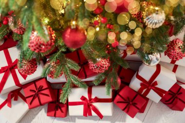 İçerideki Noel ağacının altında birçok hediye kutusu var.