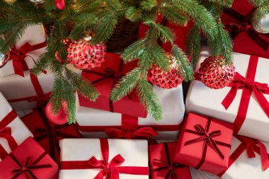 İçerideki Noel ağacının altında birçok hediye kutusu var.