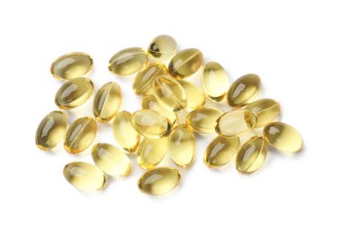 Beyaz üzerine izole edilmiş altın jelatin kapsülleri yığını