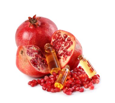 Beyaz üzerine izole edilmiş yağlı şişeler ve taze narlar.