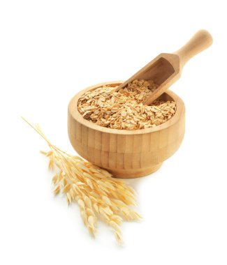 Tahta kasedeki yulaf gevrekleri, kepçeler ve çiçeklerle bembeyaz