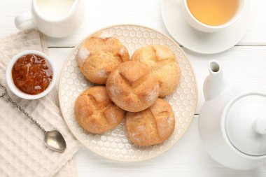 Taze çörekler, reçel ve çay beyaz ahşap masada, düz yatıyordu.