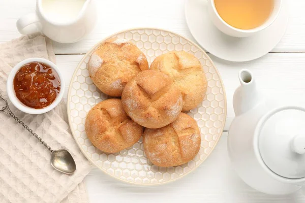 Taze çörekler, reçel ve çay beyaz ahşap masada, düz yatıyordu.