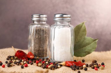 Çuval bezinde baharat olan tuzluk ve biberlikler bulanık arka planda, yakın plan