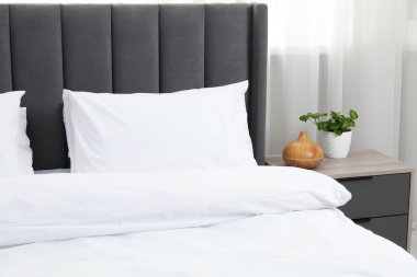 Yatak odasında temiz beyaz çarşafları olan rahat bir yatak.