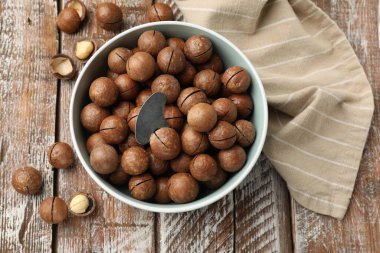 Macadamia fındıkları ve kasedeki metal anahtar tahta masada, düz yatıyordu.