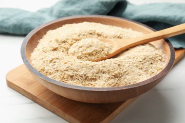 Kuru maya taneleri kasede ve kaşıklar beyaz mermer masada, yakın plan.