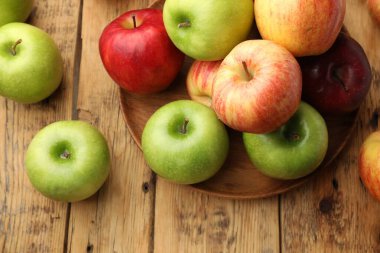 Taze taze kırmızı ve yeşil elmalar ahşap masada, düz yatıyordu.