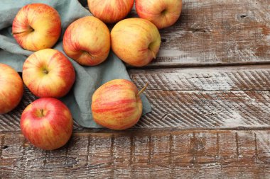 Tahta masada taze olgun kırmızı elmalar, düz bir şekilde yatıyordu. Metin için boşluk