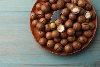 Macadamia fındıkları ve açık mavi ahşap masa üzerinde metal anahtar, üst manzara. Metin için boşluk