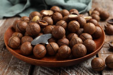 Macadamia fındıkları ve metal anahtar ahşap masada, yakın plan.