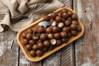 Macadamia fındıkları ve metal anahtar ahşap masada, üst manzara.