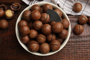 Macadamia fındıkları ve kasedeki metal anahtar tahta masada, düz yatıyordu.