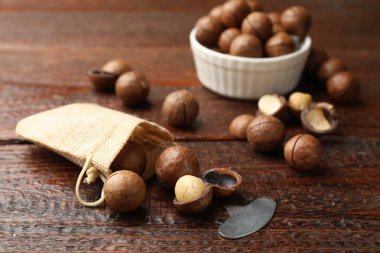 Macadamia fındıkları ve metal anahtar ahşap masada, yakın plan.