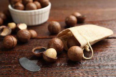 Macadamia fındıkları ve metal anahtar ahşap masada, yakın plan.