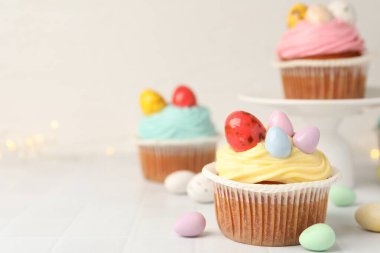 Paskalya desenli lezzetli kekler beyaz fayanslı masada, yakın plan. Metin için boşluk